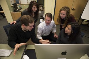 January 16, 2015 - From left, Elijah Kaplan, AMD'16, Audrey Adam, MS AMD'15, journalism Professor of the Practice Mike Beaudet, Kelsey Bruun, AMD'16, and Angel Feliciano, AMD'15, examined a potential web resource as part of Beaudet's investigative journalism class' partnership with FOX25, for which the students will produce multimedia pieces.